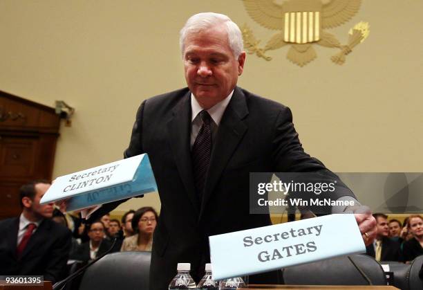 Defense Secretary Robert Gates switches name plates with U.S. Secretary of State Hillary Clinton so that her seat would be in the middle prior to...