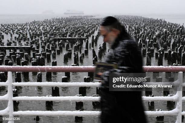 Man walks along the Hudson River during a snow storm on March 21, 2018 in Jersey City, New Jersey. At least 12 to 15 inches are expected in parts of...