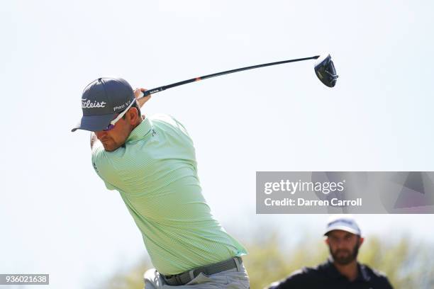 Bernd Wiesberger of Austria plays his shot from the 12th tee as Dustin Johnson of the United States looks on during the first round of the World Golf...