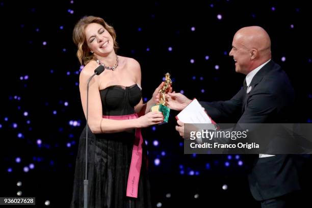 Claudia Gerini receives the Best Supporting Actress Award from Luca Zingaretti during the 62nd David Di Donatello awards ceremony on March 21, 2018...