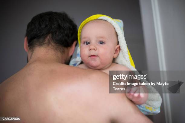 dad carries baby boy with towel - envuelto en una toalla fotografías e imágenes de stock