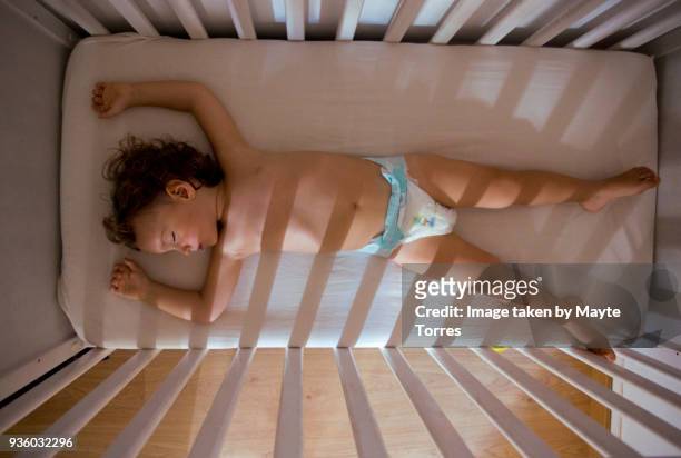 toddler taking a nap in crib from above - baby sommer stockfoto's en -beelden