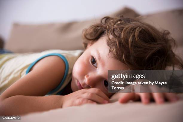 sad toddler lying on his stomach - sick child stockfoto's en -beelden