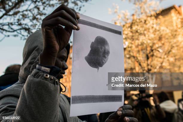 Man shows a picture of Mmame Mbaye, a Senegalese street vendor who died of cardiac arrest, supposedly during a police raid. The Senegalese community...