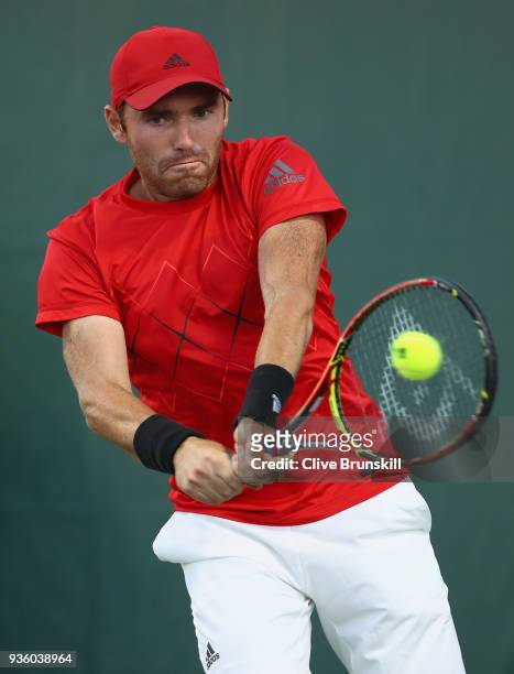 Bjorn Fratangelo of the United States plays a backhand against Liam Broady of Great Britain in their first round match during the Miami Open...