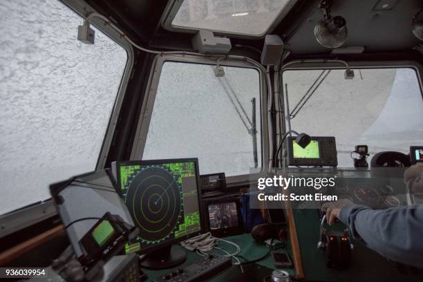 Waves crash over the windows of the pilot boat "Chelsea" as it drives close behind the stern of the oil tanker "Nor'Easter," to avoid large waves as...