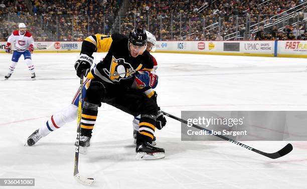 Evgeni Malkin of the Pittsburgh Penguins is is held by Jacob de la Rose of the Montreal Canadiens at PPG Paints Arena on March 21, 2018 in...