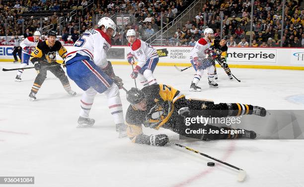 Evgeni Malkin of the Pittsburgh Penguins is is held by Jacob de la Rose of the Montreal Canadiens at PPG Paints Arena on March 21, 2018 in...