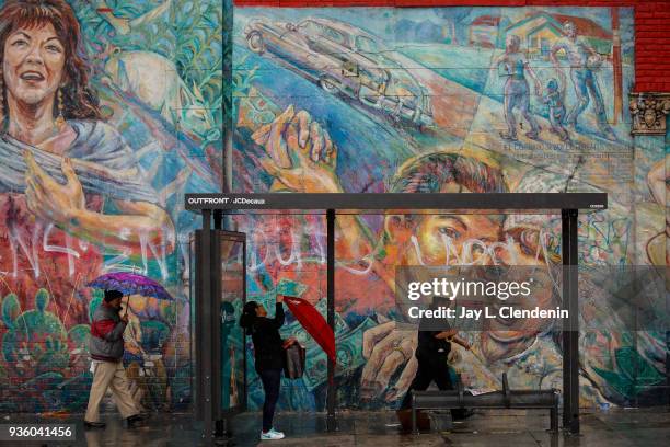 With a classic Boyle Heights neighborhood mural along Soto Street as a backdrop, Angelenos deal with a lingering rain storm over Los Angeles, CA,...