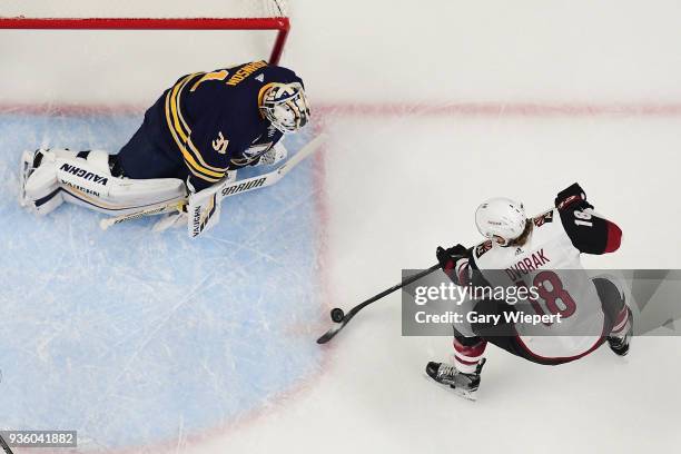 Chad Johnson of the Buffalo Sabres defends against Christian Dvorak of the Arizona Coyotes during an NHL game on March 21, 2018 at KeyBank Center in...