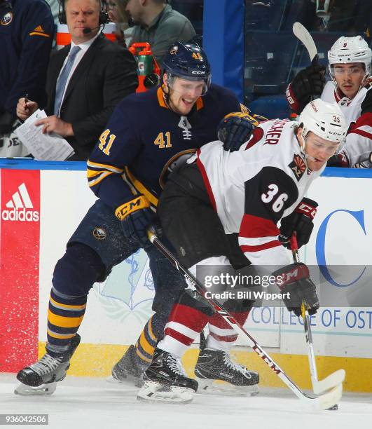 Justin Falk of the Buffalo Sabres checks Christian Fischer of the Arizona Coyotes during an NHL game on March 21, 2018 at KeyBank Center in Buffalo,...