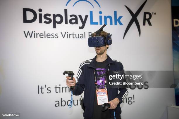 An attendee wears an HTC Corp. Vive virtual reality headset while demonstrating DisplayLink Corp. Wireless connectivity during the Game Developers...