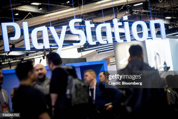 Attendees walk past the Sony Corp. Playstation display during the Game Developers Conference in San Francisco, California, U.S., on Wednesday, March...