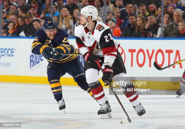 Oliver Ekman-Larsson of the Arizona Coyotes controls the puck against Johan Larsson of the Buffalo Sabres during an NHL game on March 21, 2018 at...