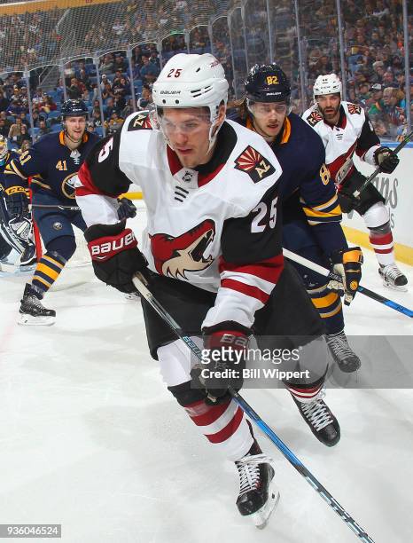 Nathan Beaulieu of the Buffalo Sabres and Nick Cousins of the Arizona Coyotes chase the puck along the boards during an NHL game on March 21, 2018 at...