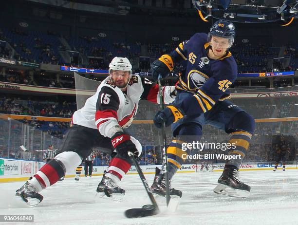 Brendan Guhle of the Buffalo Sabres and Brad Richardson of the Arizona Coyotes battle for the puck along the boards during an NHL game on March 21,...