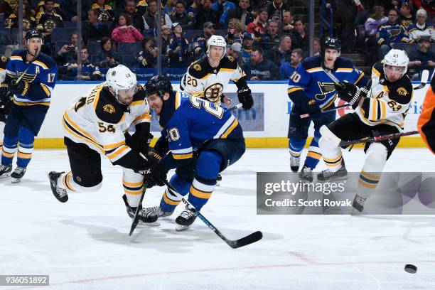 Adam McQuaid of the Boston Bruins knocks the puck away from Alexander Steen of the St. Louis Blues at Scottrade Center on March 21, 2018 in St....