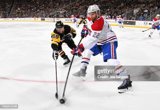 Jake Guentzel of the Pittsburgh Penguins battles for the loose puck against Karl Alzner of the Montreal Canadiens at PPG Paints Arena on March 21,...