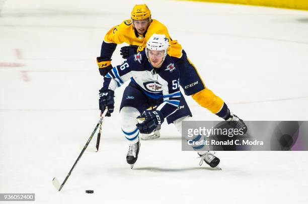 Marko Dano of the Winnipeg Jets skates against Kevin Fiala of the Nashville Predators during an NHL game at Bridgestone Arena on March 13, 2018 in...