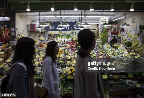 People walk past a vegetable stall at Omicho Market in Kanazawa, Japan, on Monday, March 19, 2018. Japan is scheduled to release February's Consumer...