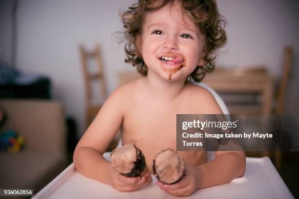 toddler licking his face holding two icecreams - candy on tongue stock pictures, royalty-free photos & images