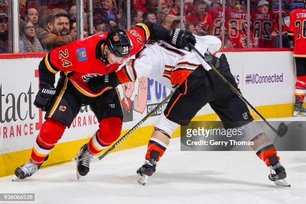 Travis Hamonic of the Calgary Flames and Adam Henrique of the Anaheim Ducks battle for position in an NHL game on March 21, 2018 at the Scotiabank...