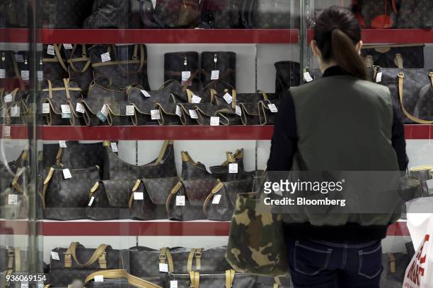 Customer looks at second-hand LVMH Moet Hennessy Louis Vuitton SE bags displayed for sale at a Daikokuya Inc. Store in the Shinjuku district of...