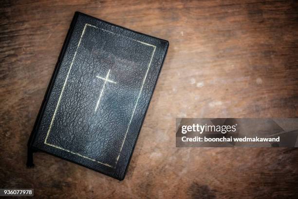 glow illuminating the holy bible in the dark. - bible stockfoto's en -beelden