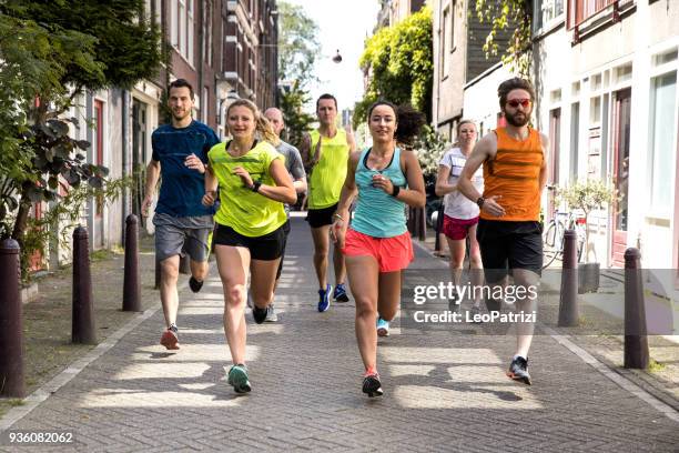 urban runners crew training in the city - street running stock pictures, royalty-free photos & images