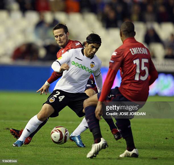 Valencia's Argentinian midfielder Ever Banega tries to get the ball past Lille's Yohan Cabaye and Emerson during their Europe league football match...