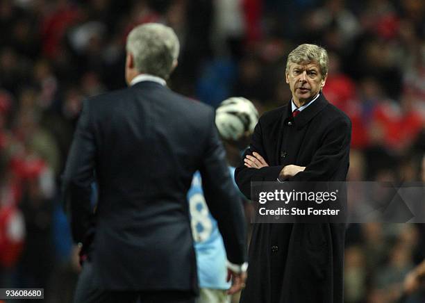 Man City manager Mark Hughes and Arsene Wenger have words during the Carling Cup quarter final match between Manchester City and Arsenal at City of...