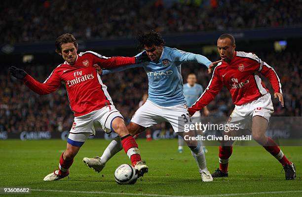 Carlos Tevez of Manchester City holds off a challenge from Mikael Silvestre and Tomas Rosicky of Arsenal during the Carling Cup quarter final match...