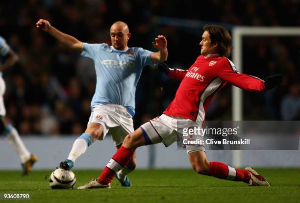 Tomas Rosicky of Arsenal tackles Stephen Ireland of Manchester City during the Carling Cup quarter final match between Manchester City and Arsenal at...