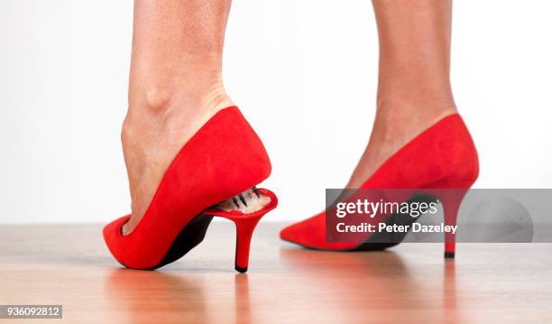 snapped heel on red stilettos - woman in broken shoe heel stockfoto's en -beelden