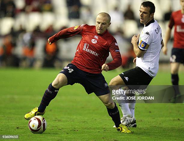 Valencia's captain and defender Carlos Marchena fights for the ball with Lille's Florent Balmont during their Europe league football match at...
