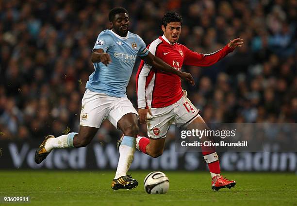 Kolo Toure of Manchester City attempts to move past Carlos Vela of Arsenal during the Carling Cup quarter final match between Manchester City and...