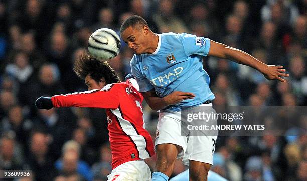 Manchester City's Belguim midfielder Vincent Kompany heads clear from Arsenal's Czech midfielder Tomas Rosicky during the Carling Cup quarter final...