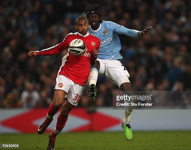 Emmanuel Adebayor of Man City challenges Armand Traore during the Carling Cup quarter final match between Manchester City and Arsenal at City of...