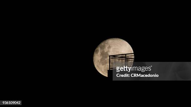 a huge  blood moon  on the home balcony. - crmacedonio stock pictures, royalty-free photos & images