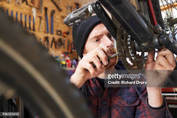 bicycle mechanic at work - bike shop stock pictures, royalty-free photos & images