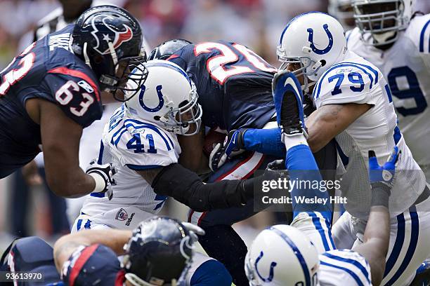 Running back Steve Slaton of the Houston Texans is tackled by defensive back Antoine Bethea and defensive end Raheem Brock of the Indianapolis Colts...
