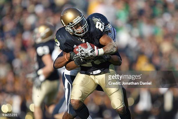 Golden Tate of the Notre Dame Fighting Irish grips the ball as he is tackled during the game against the Univeristy of Connecticut Huskies at Notre...
