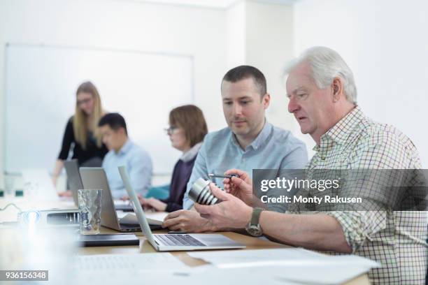 younger and older scientists discussing pharmaceutical science project in meeting room - older woman younger man stock-fotos und bilder