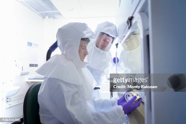 scientists working in protective wear in laboratory - clean suit fotografías e imágenes de stock
