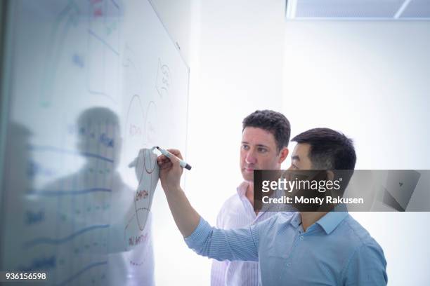 scientists drawing on white board in meeting room - collaborate whiteboard stock pictures, royalty-free photos & images