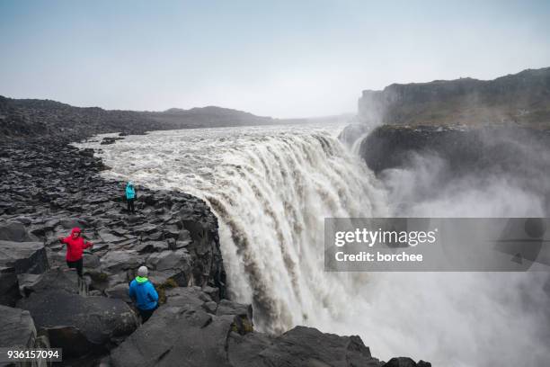 tourists photographing dettifoss in iceland - dettifoss waterfall stock pictures, royalty-free photos & images