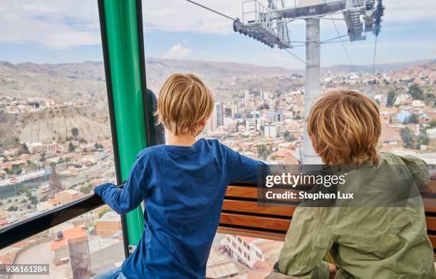 two boys in cable car, looking our of window at view, rear view, la paz, bolivia, south america - la paz - bolivia stock pictures, royalty-free photos & images