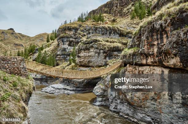 inca rope bridge crossing river ravine, huinchiri, cusco, peru - touwbrug stockfoto's en -beelden