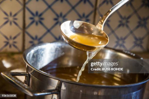 broth being ladled from saucepan - broth stock pictures, royalty-free photos & images