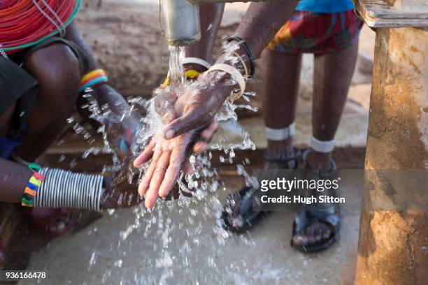 women collecting clean water from borehole in desert. samburu. kenya. - hugh sitton stock-fotos und bilder